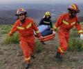 Спасатели несут носилки на месте ультрамарафонского забега в Ганьсу